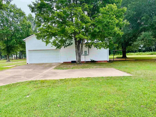 a view of a yard with a house and large trees