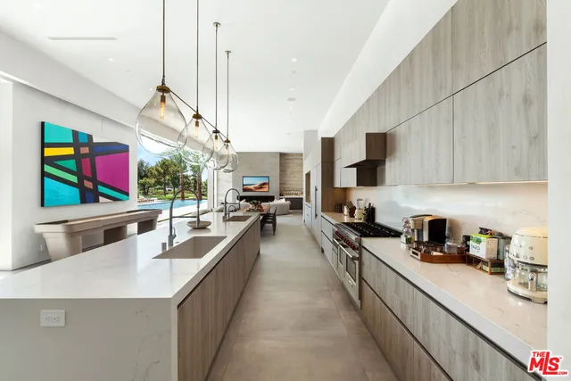 a kitchen with stainless steel appliances a sink a counter top space cabinets and stove top oven