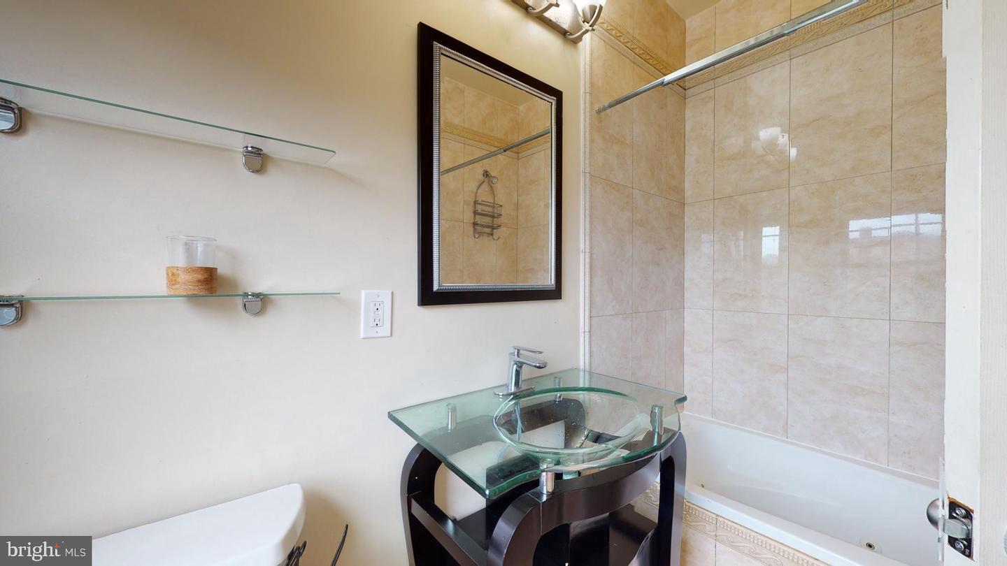 615 16th Street Northeast Washington, DC 20002 - Photo 21 of 33 a bathroom with a granite countertop sink a mirror and a shower