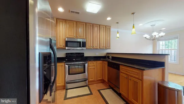 a kitchen with stainless steel appliances granite countertop a stove a sink and a refrigerator