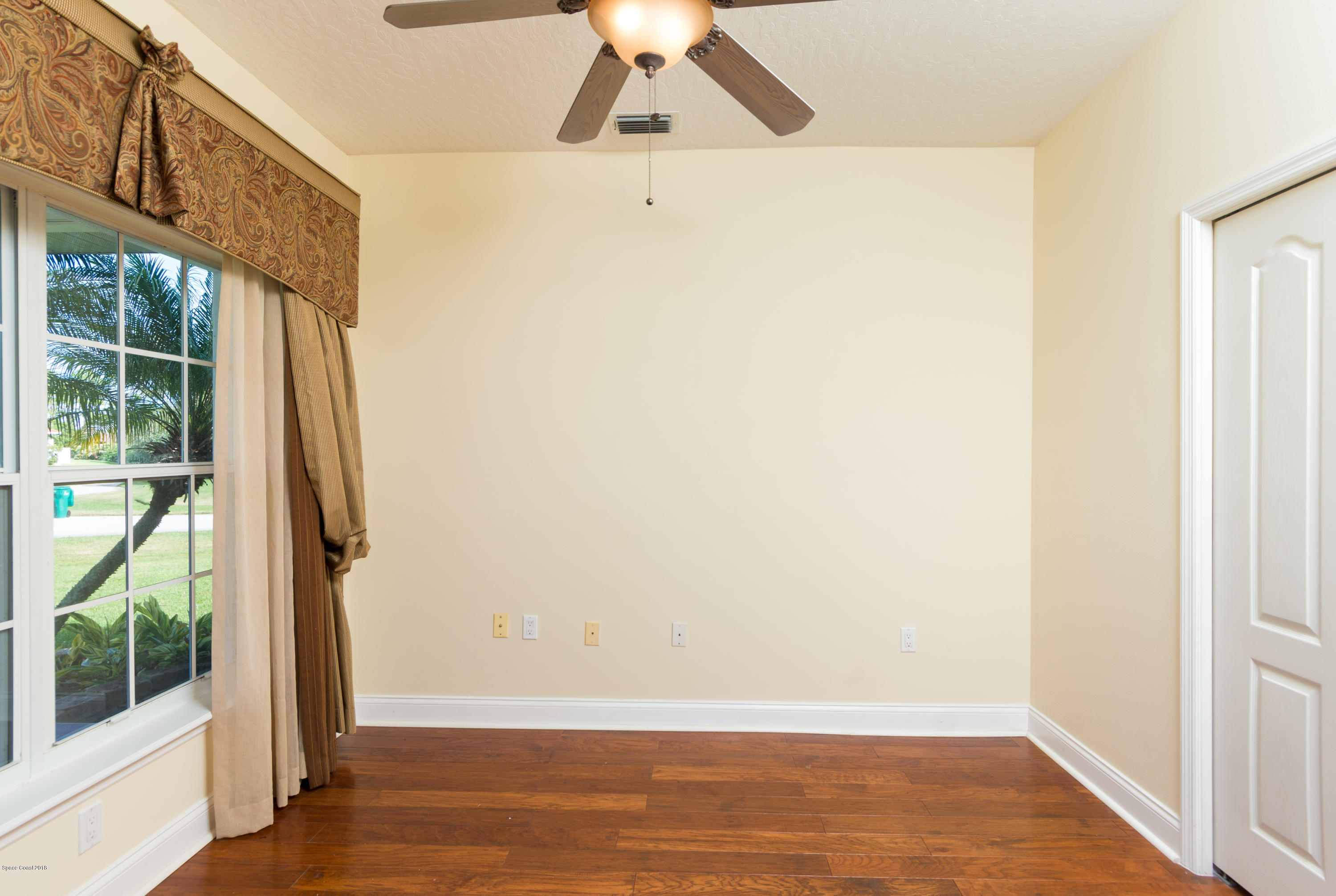 3420 Shady Run Road Melbourne, FL 32934 - Photo 27 of 33 an empty room with wooden floor and windows