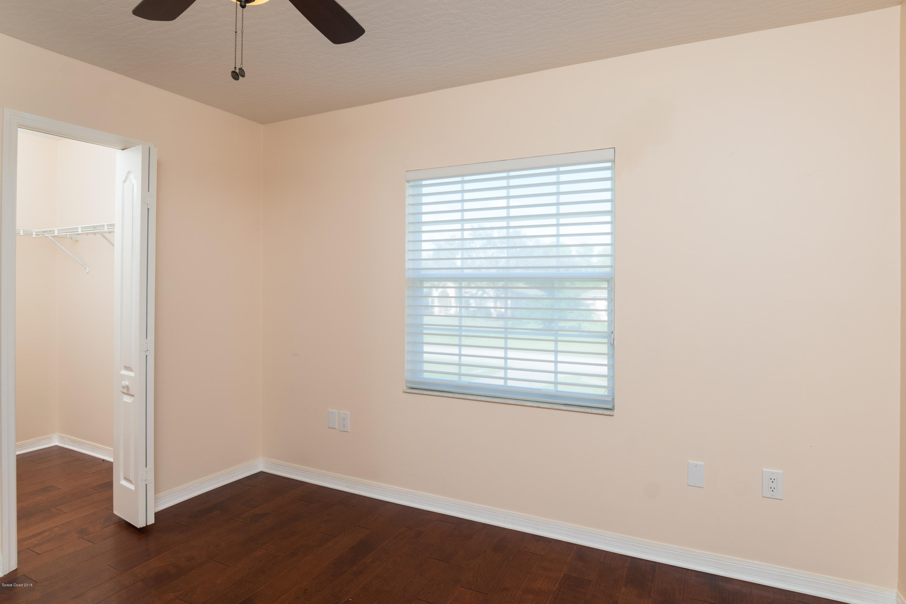 3420 Shady Run Road Melbourne, FL 32934 - Photo 28 of 33 an empty room with wooden floor cabinet and windows