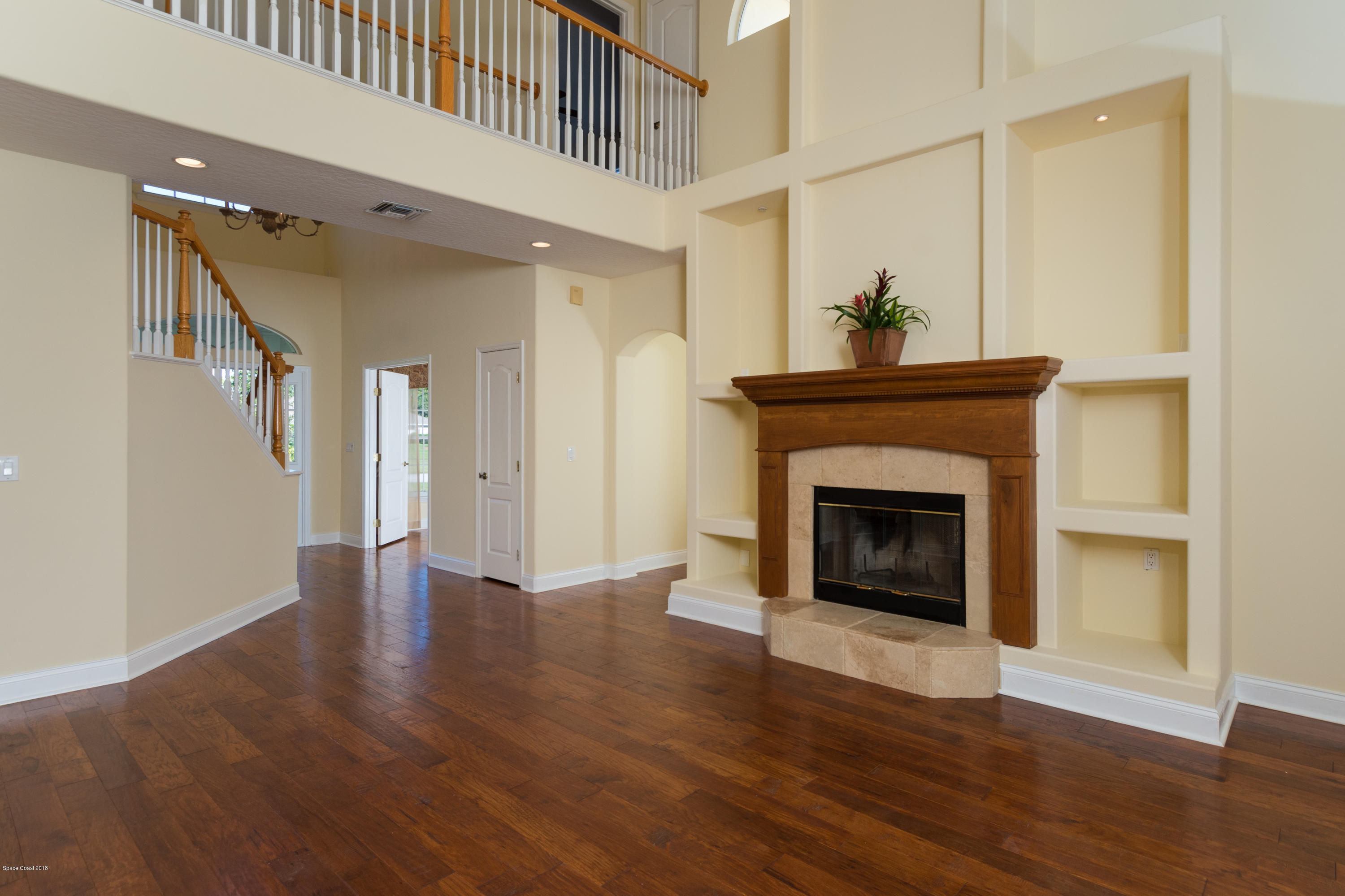 3420 Shady Run Road Melbourne, FL 32934 - Photo 7 of 33 a view of an empty room with wooden floor and a fireplace