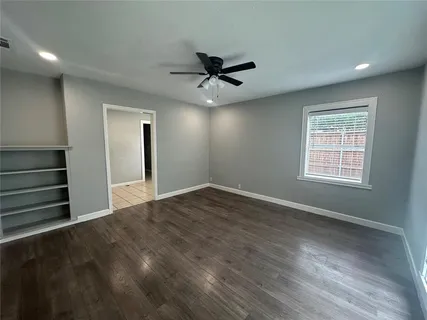 an empty room with windows and fan
