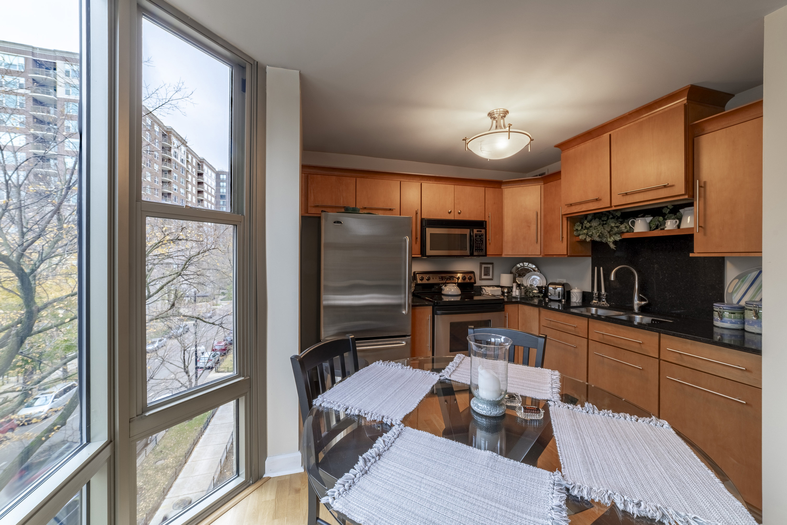 1340 North Dearborn Street, Unit 5C Chicago, IL 60610 - Photo 17 of 44 a kitchen with stainless steel appliances granite countertop a refrigerator a sink dishwasher a stove and a dining table with wooden floor