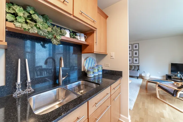 a kitchen with stainless steel appliances granite countertop a sink a stove and a wooden floor