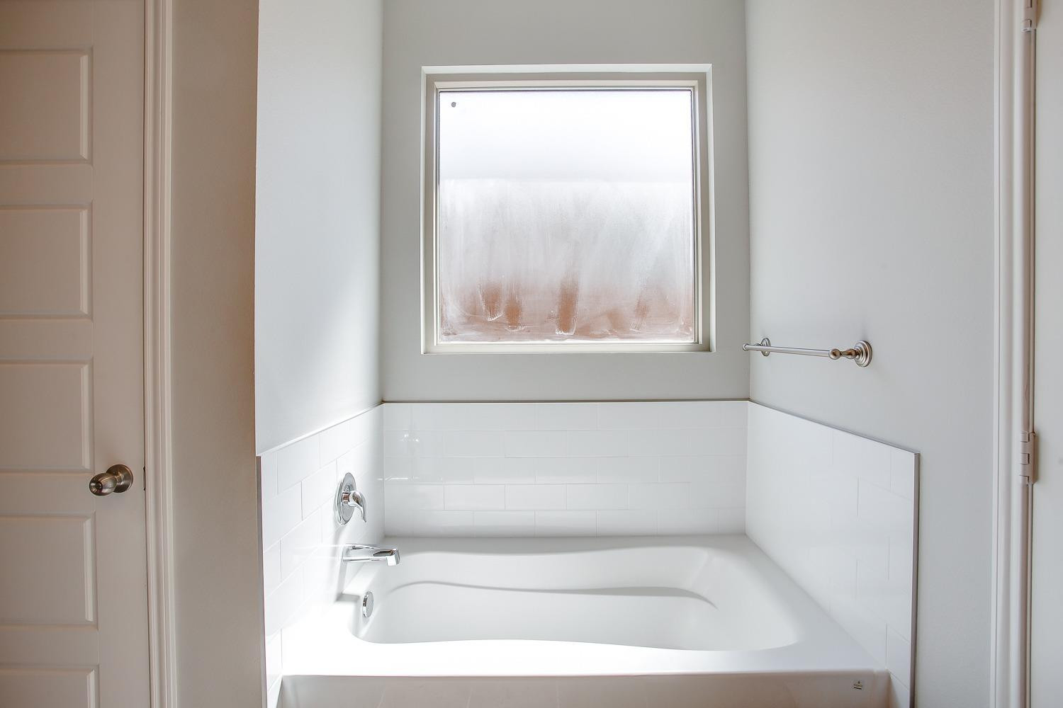 5804 Winfield Avenue Lubbock, TX 79407 - Photo 11 of 18 a white bath tub sitting next to a white sink