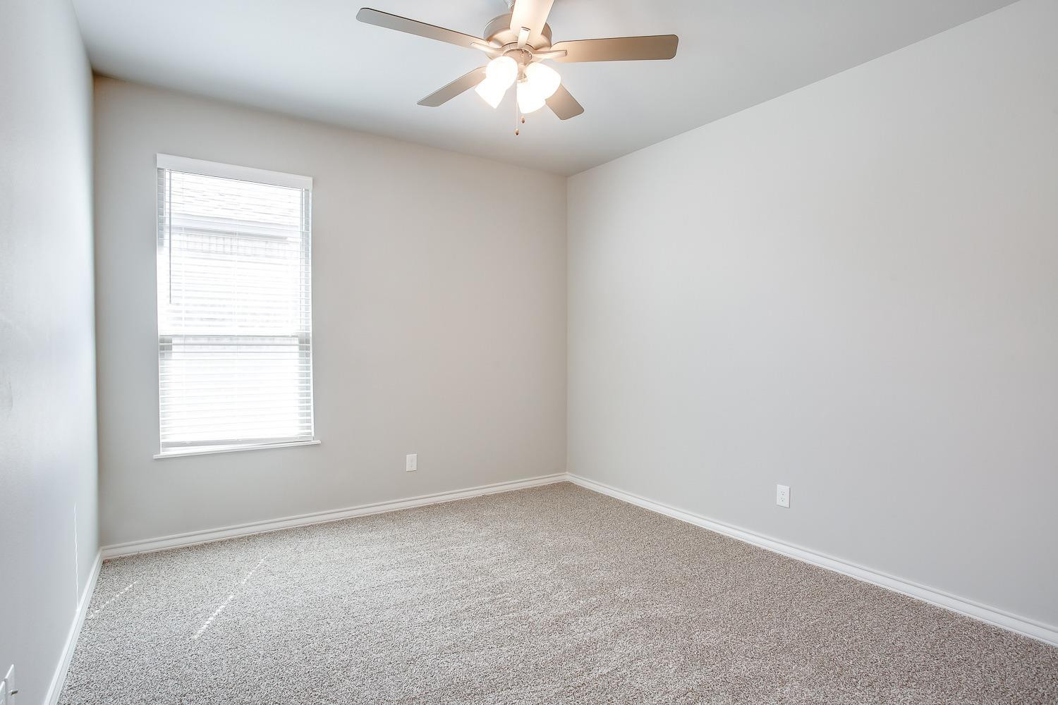 5804 Winfield Avenue Lubbock, TX 79407 - Photo 15 of 18 an empty room with a window and a fan