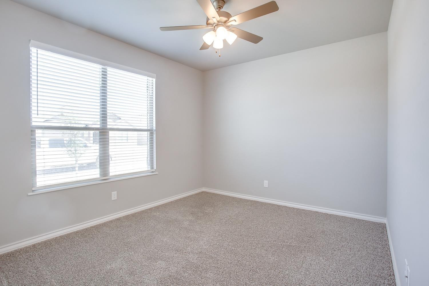 5804 Winfield Avenue Lubbock, TX 79407 - Photo 16 of 18 an empty room with a window and a fan