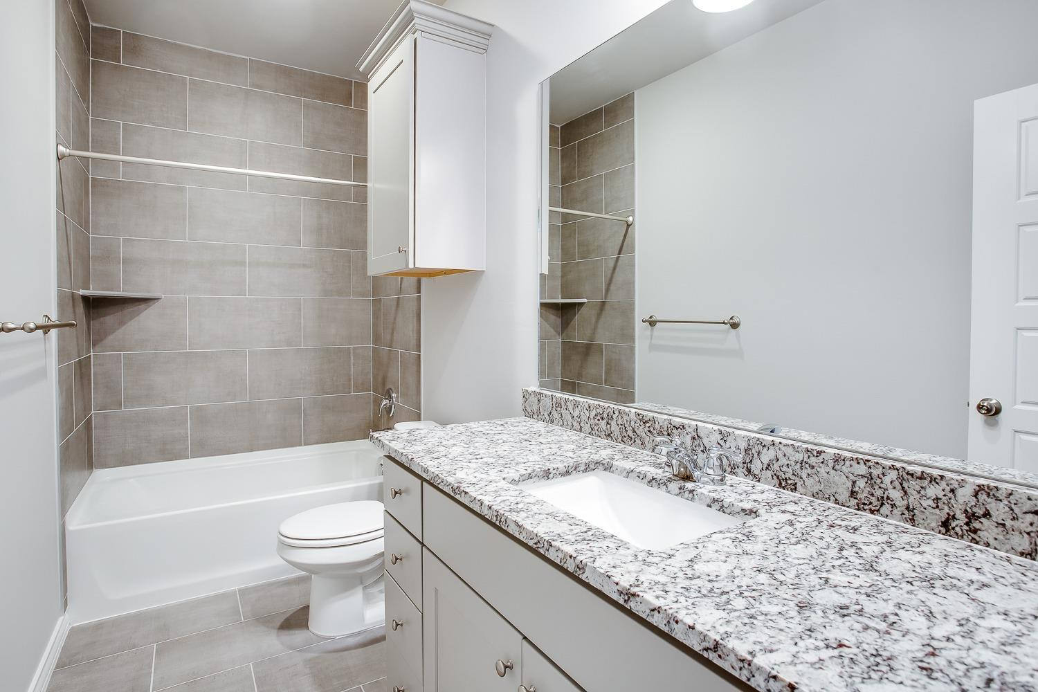 5804 Winfield Avenue Lubbock, TX 79407 - Photo 17 of 18 a bathroom with a granite countertop sink a toilet and shower