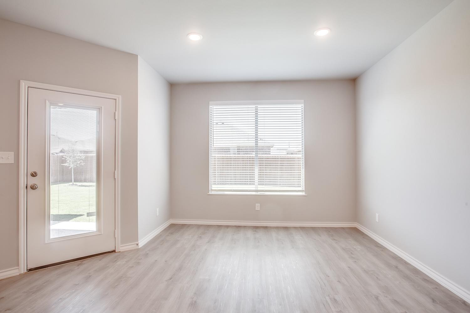 5804 Winfield Avenue Lubbock, TX 79407 - Photo 8 of 18 an empty room with wooden floor and windows