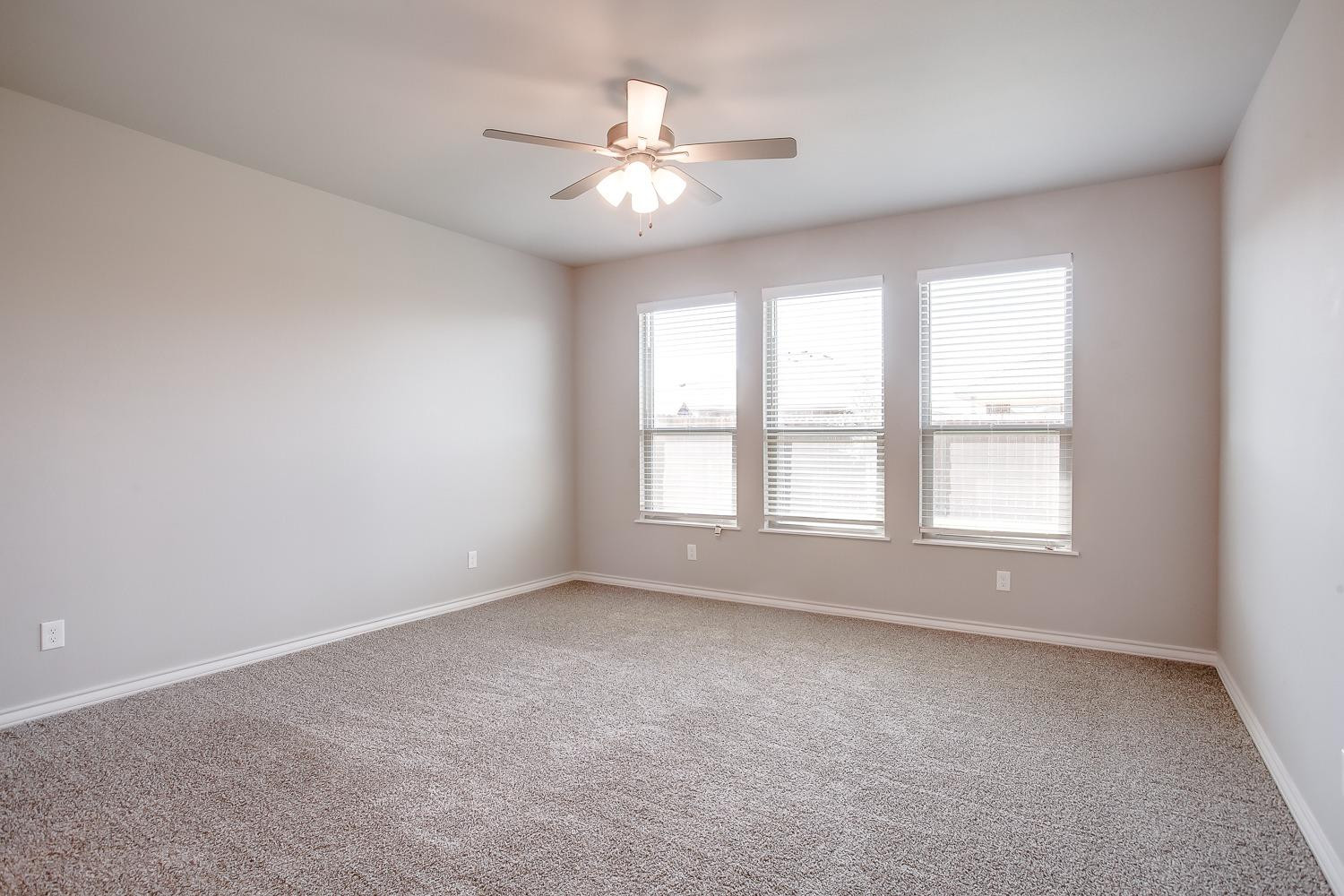 5804 Winfield Avenue Lubbock, TX 79407 - Photo 9 of 18 an empty room with chandelier fan and windows