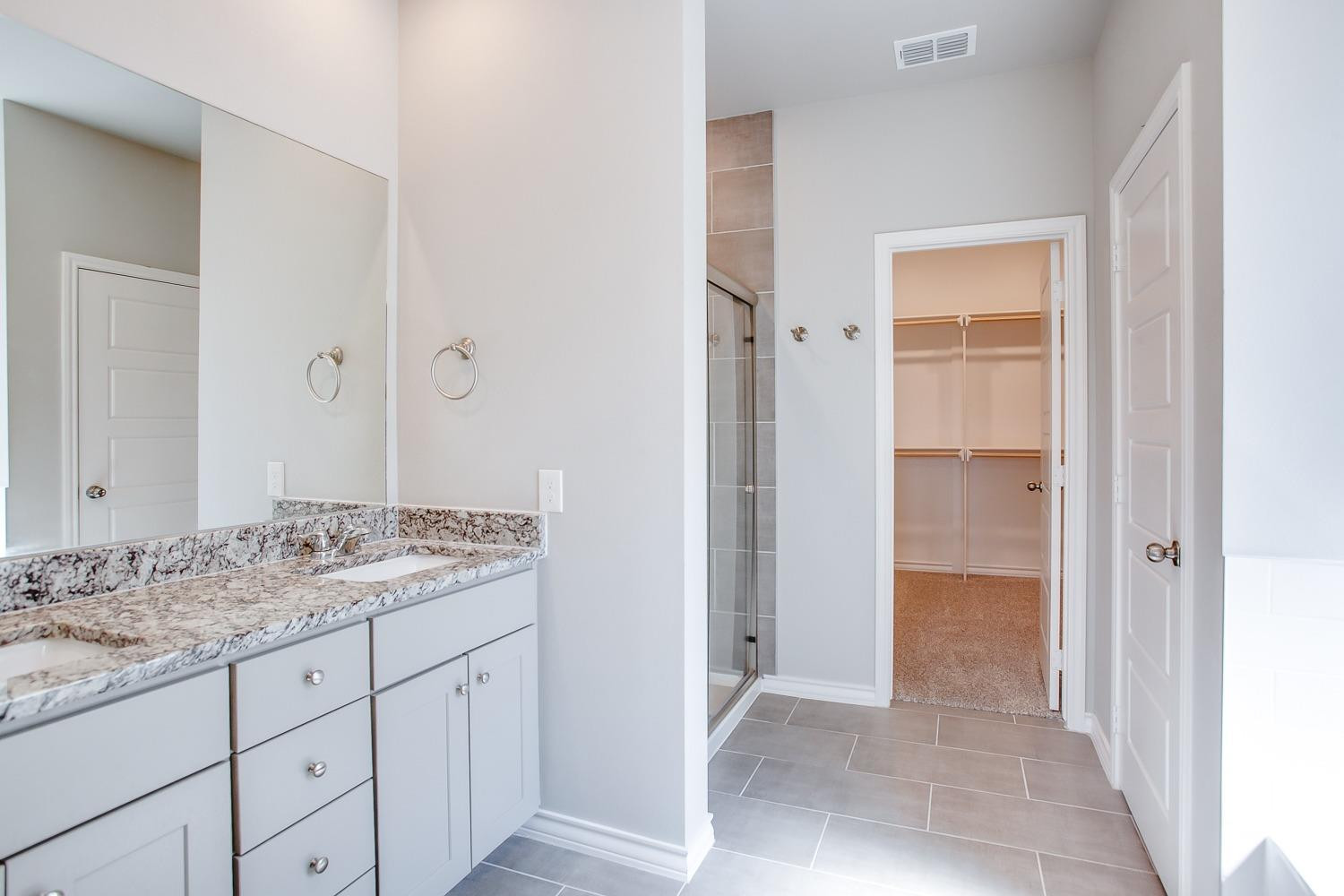 5804 Winfield Avenue Lubbock, TX 79407 - Photo 10 of 18 a bathroom with a granite countertop sink and a mirror