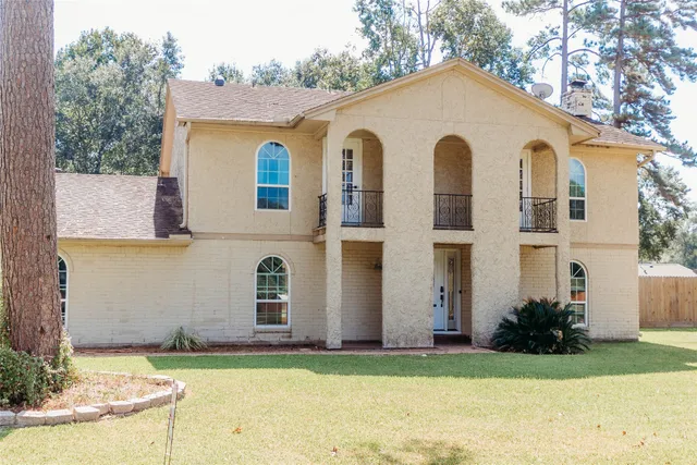 a view of a white house with yard and plants