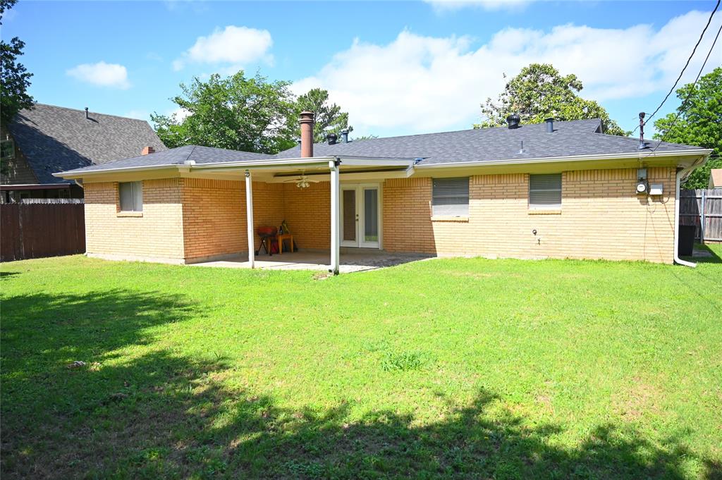 1352 Simpson Drive Hurst, TX 76053 - Photo 6 of 40 Expansive backyard featuring a brick exterior, covered patio, dark shingle roofing, and a privacy fence
