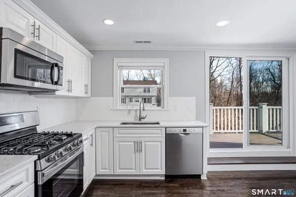 a kitchen with granite countertop a sink and a stove top oven