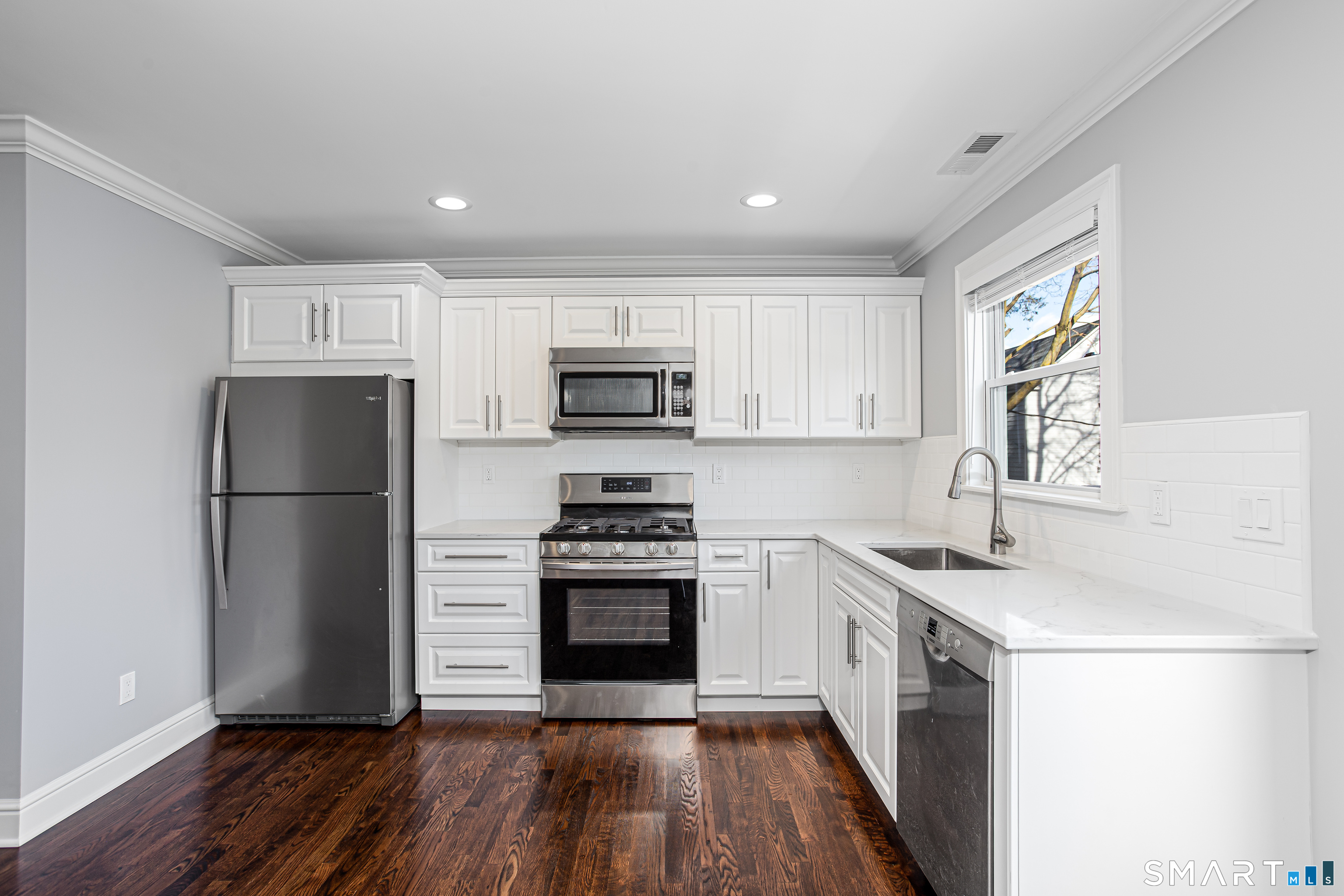 65 Mason Street Fairfield, CT 06825 - Photo 18 of 30 a kitchen with a sink a refrigerator a microwave and cabinets