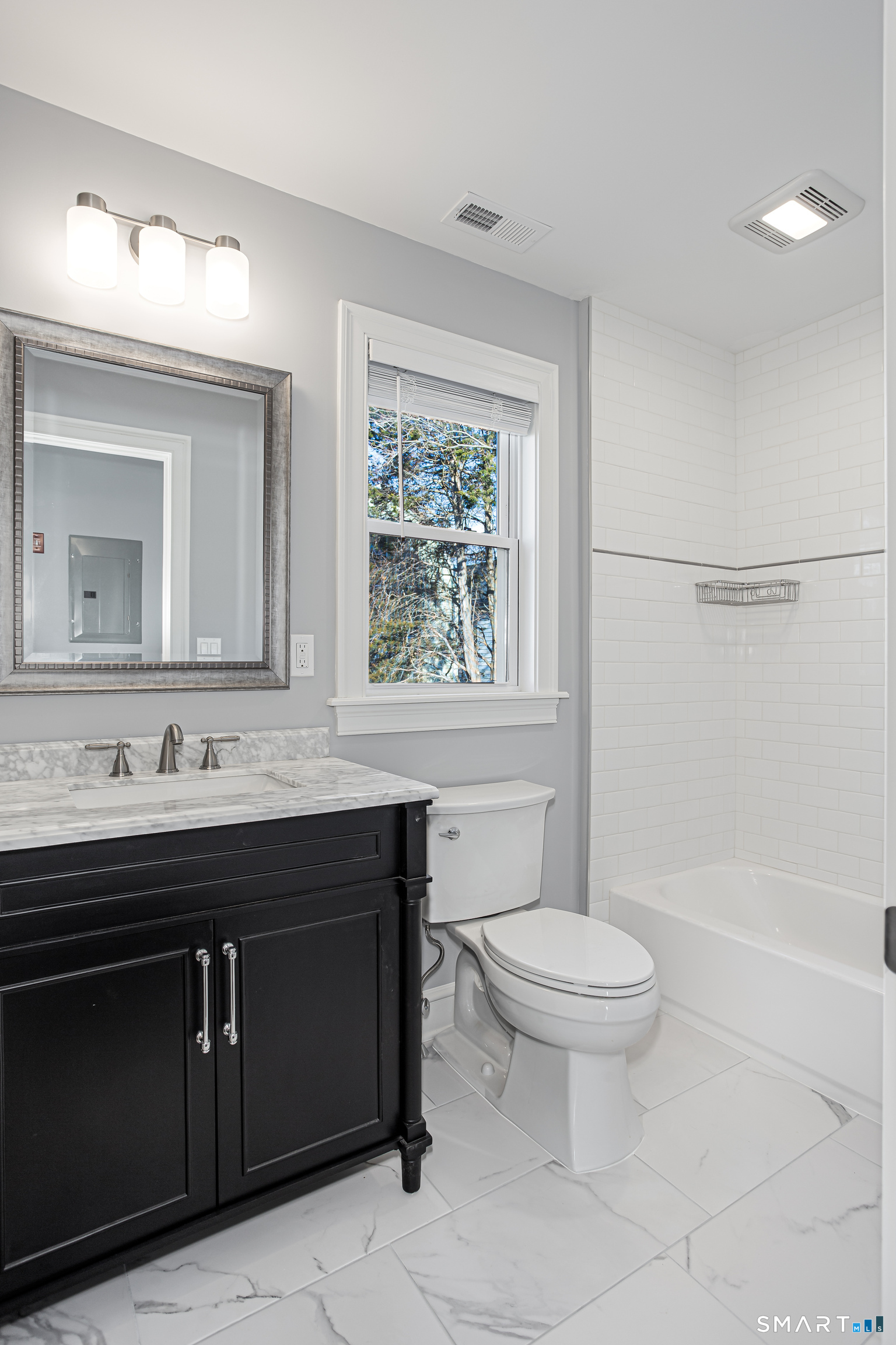 65 Mason Street Fairfield, CT 06825 - Photo 24 of 30 a bathroom with a granite countertop toilet a sink a mirror and a window