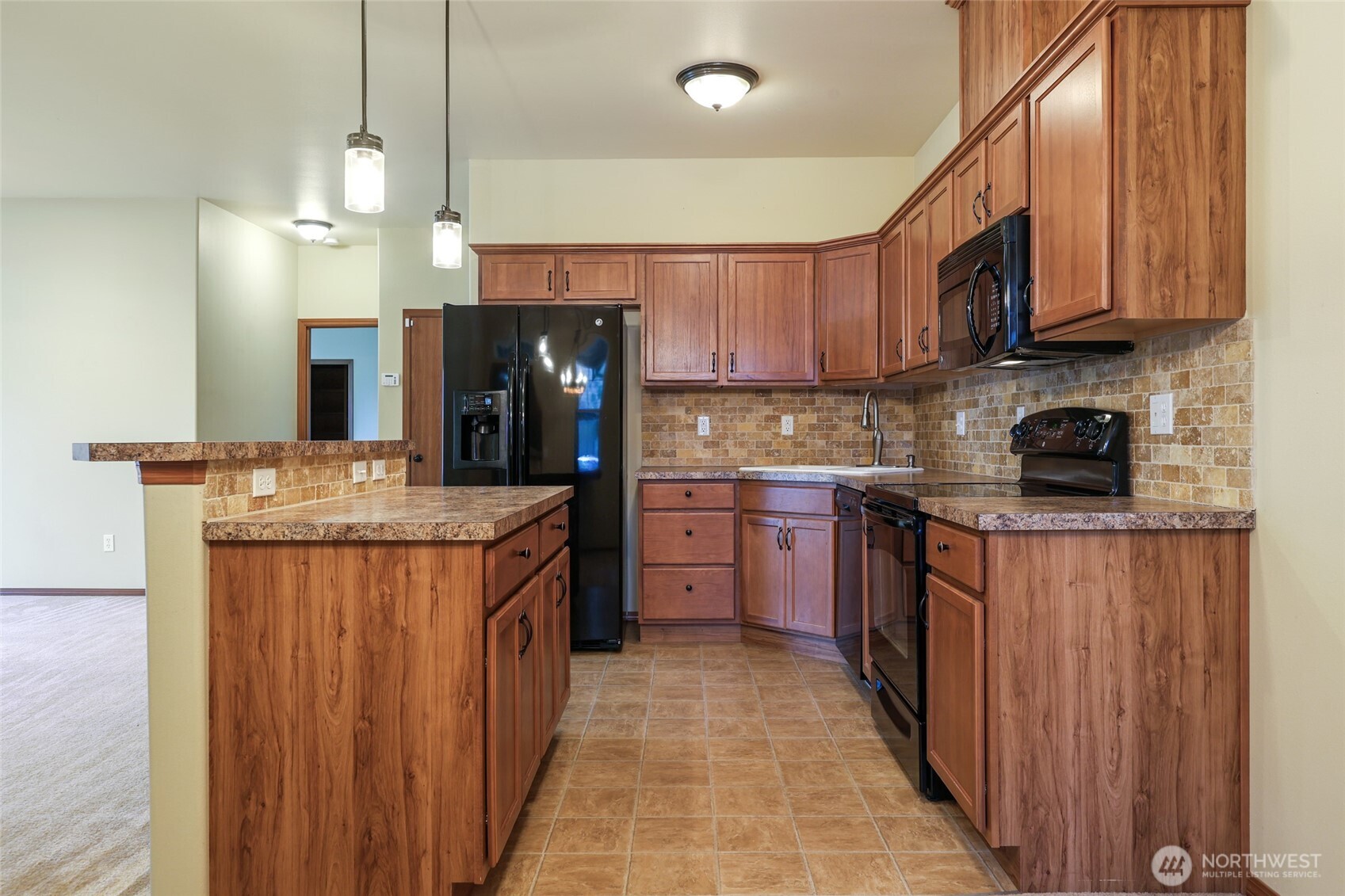 5107 66th Avenue Southeast Lacey, WA 98513 - Photo 21 of 27 a kitchen with stainless steel appliances granite countertop a stove top oven a sink dishwasher and a refrigerator with wooden cabinets
