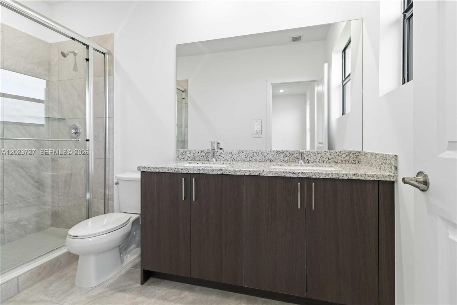 22348 Southwest 115th Court, Unit 22348 Miami, FL 33170 - Photo 23 of 37 a bathroom with a granite countertop sink a toilet and shower