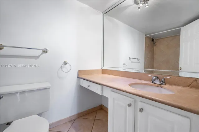 a bathroom with a granite countertop toilet sink and a mirror