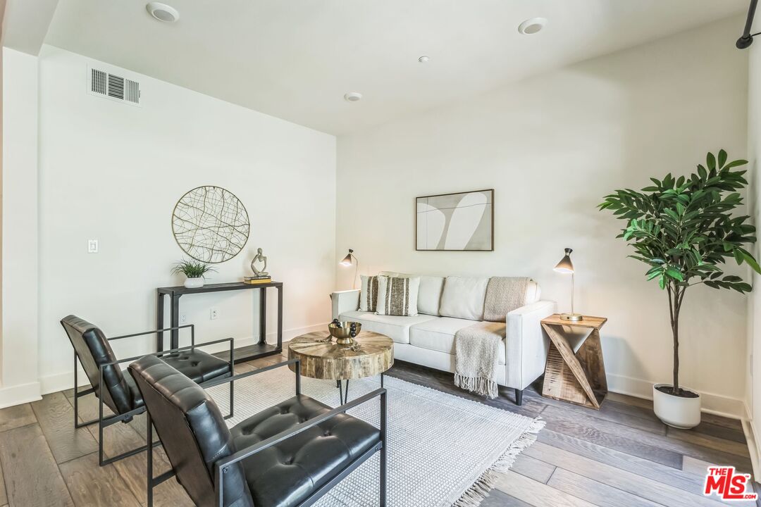 2976 Ripple Place, Unit 103 Los Angeles, CA 90039 - Photo 3 of 16 a living room with furniture a clock and a potted plant