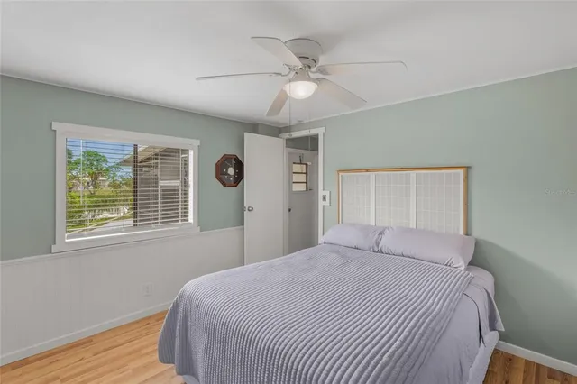 a view of an empty room with window and chandelier fan
