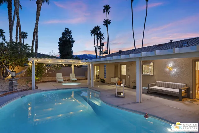 a view of a patio with a table and chairs under an umbrella with a fire pit