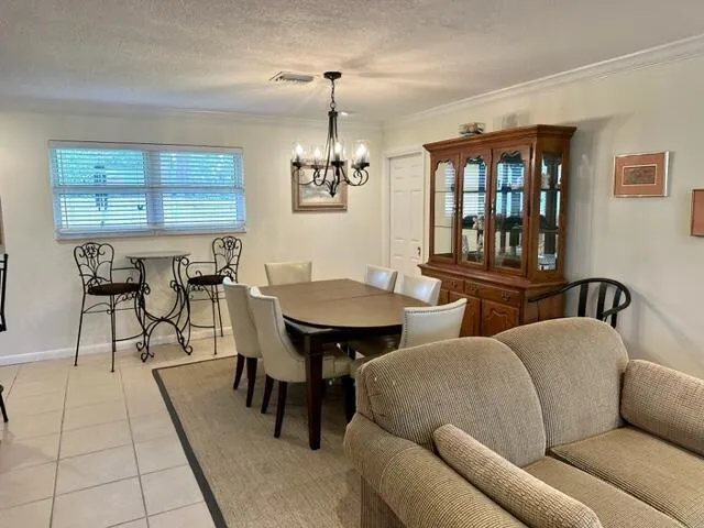 a living room with furniture a chandelier and a dining table