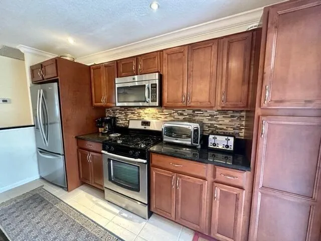 a kitchen with stainless steel appliances granite countertop a refrigerator stove and microwave