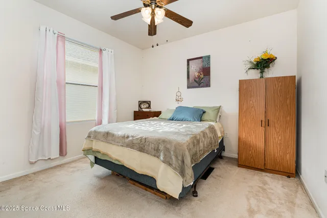 a spacious bedroom with a bed and a chandelier