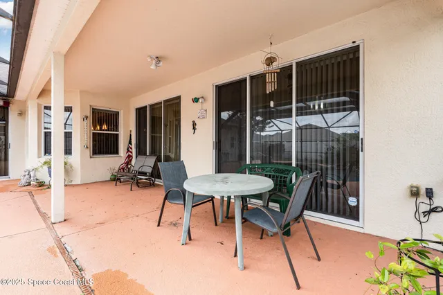 a backyard of a house with table and chairs