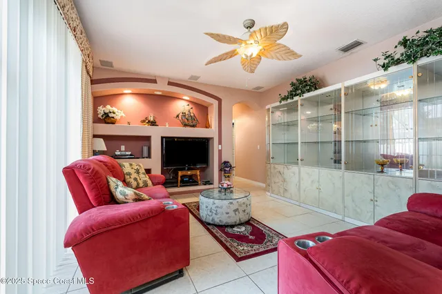a living room with furniture a flat screen tv and a floor to ceiling window