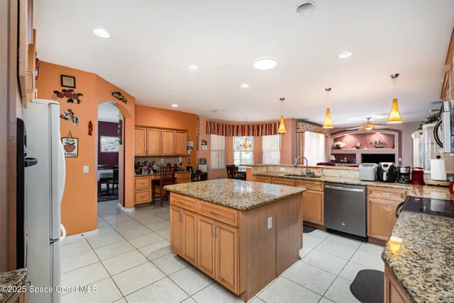 a kitchen with stainless steel appliances granite countertop a sink and a refrigerator