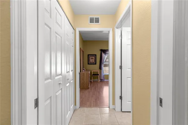 a view of a hallway with wooden floor and a living room