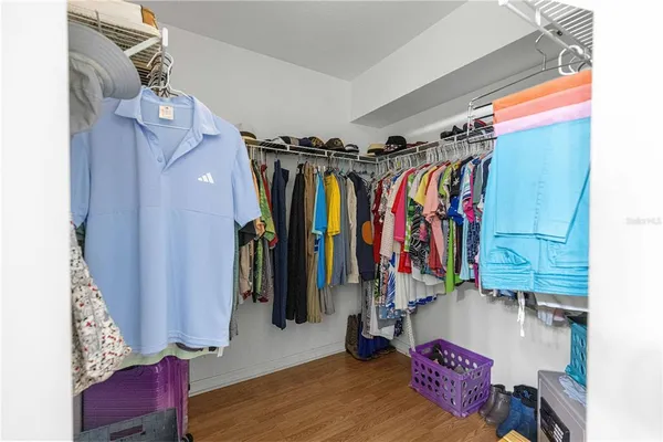 a view of walk in closet with clothes