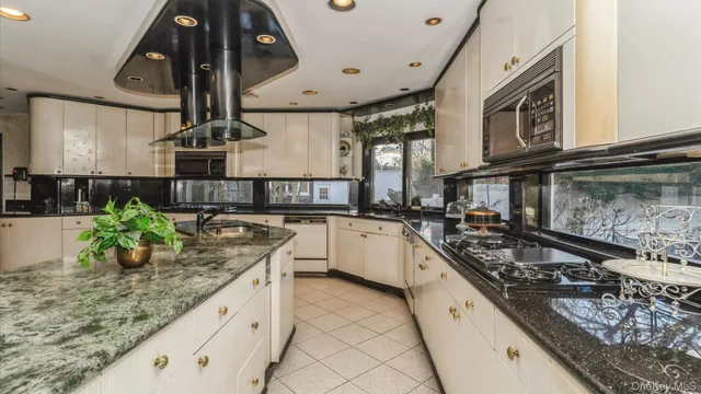 a kitchen with stainless steel appliances granite countertop a sink a stove and a wooden floors
