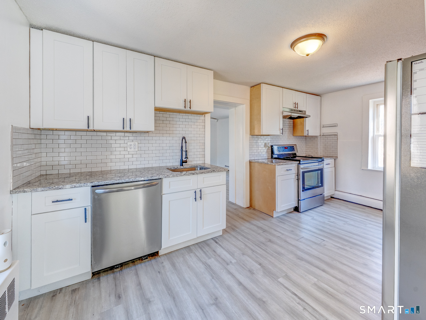 7 Rose Street Norwich, CT 06360 - Photo 13 of 37 a kitchen with cabinets wooden floor and stainless steel appliances
