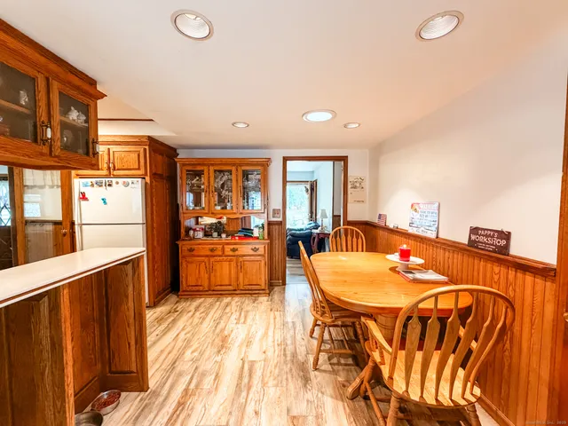 a dining hall with stainless steel appliances a dining table and chairs with wooden floor