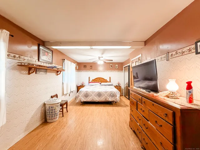 a bedroom with a bed and a flat tv screen on dresser