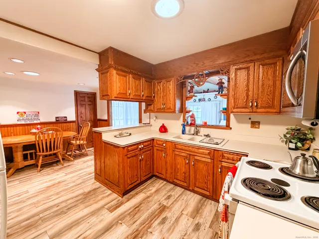 a kitchen with stainless steel appliances a stove a sink dishwasher and a refrigerator with wooden floor