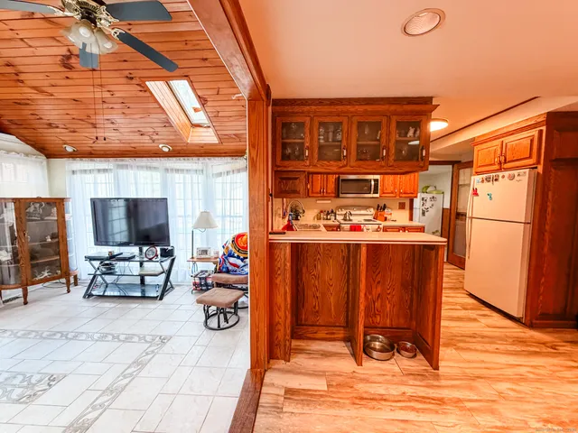 a living room with blue lights with furniture and a kitchen view
