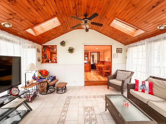 a living room with furniture a flat screen tv and gym equipment
