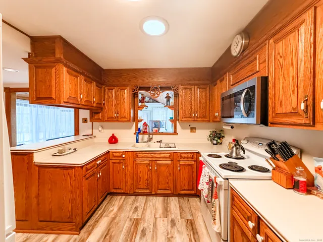 a kitchen that has a sink a stove and a wooden cabinets
