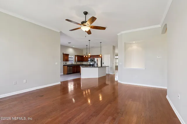 a kitchen with stainless steel appliances granite countertop a refrigerator a oven a sink dishwasher and a wooden floor