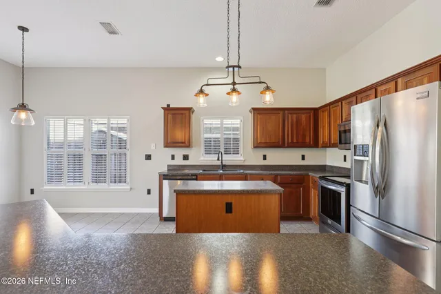 a kitchen with stainless steel appliances granite countertop a sink a stove and a refrigerator