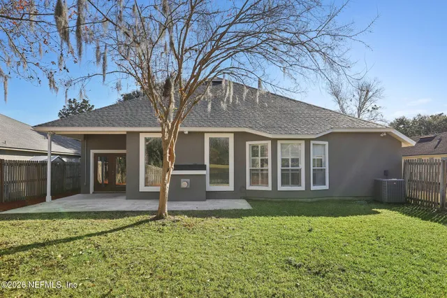 a view of a house with a yard and tree