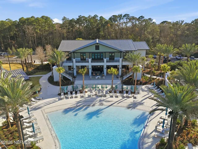 an aerial view of a house with swimming pool and furniture