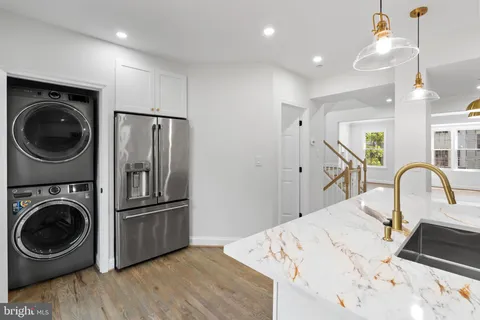 a bedroom with a bed and a dresser with wooden floor