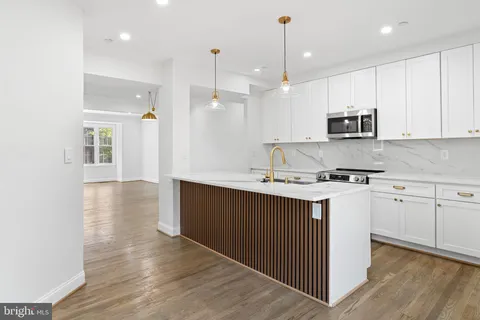 a kitchen with kitchen island a sink stainless steel appliances and cabinets